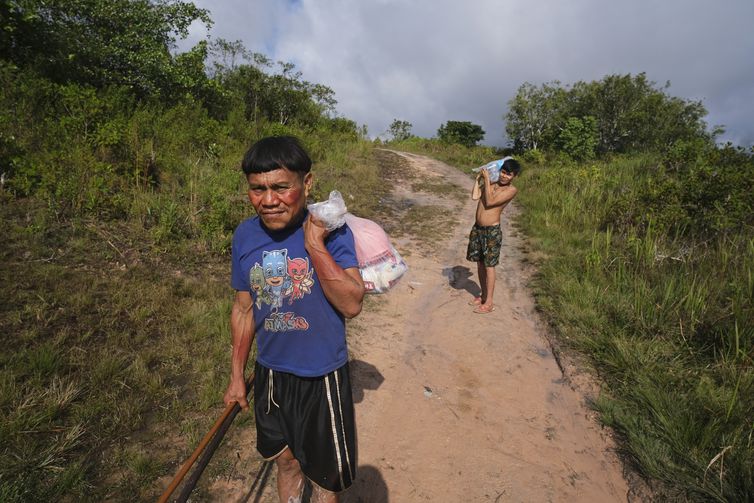 Surucucu (RR), 09/02/2023 - Pedro e Natanael, homens yanomami caminham com suprimentos em trilha no Surucucu, na Terra Indígena Yanomami.  Foto: Fernando Frazão/Agência Brasil