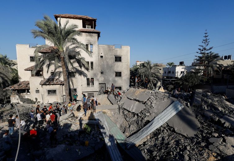 Palestinians gather at the site of Israeli strikes on houses, as the conflict between Israel and Palestinian Islamist group Hamas continues, in Khan Younis in the southern Gaza Strip, October 26, 2023. REUTERS/Mohammed Salem