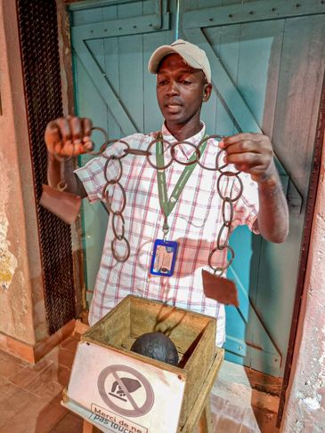 Dacar (Senegal) 30/11/2023 – Guia exibe grilhões usados para atar pés e mãos de africanos escravizados na ilha de Gorée, no Senegal - Com pouco mais de 1 mil habitantes, Ilha de Gorée fica a pouco quilômetros de Dacar e um dos principais pontos turísticos do Senegal.  
Foto: Pedro Rafael Vilela/Agência Brasil