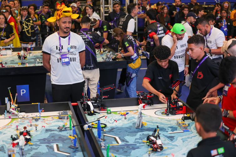 Fabio Rodrigues-Pozzebom/ Agência Brasil Brasília (DF) 14/03/2025 Estudantes de vários locais do país participam do Torneio Sesi de robótica. O árbitro João Silva ( de chapéu de girafa), fala com a Agência Brasil Foto: Fabio Rodrigues-Pozzebom/ Agência Brasil