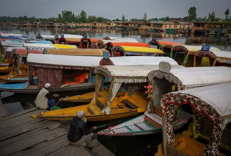 Reuters/Adnan Abidi/Proibida reprodução Kashmiri men catch fish as they sit next to parked