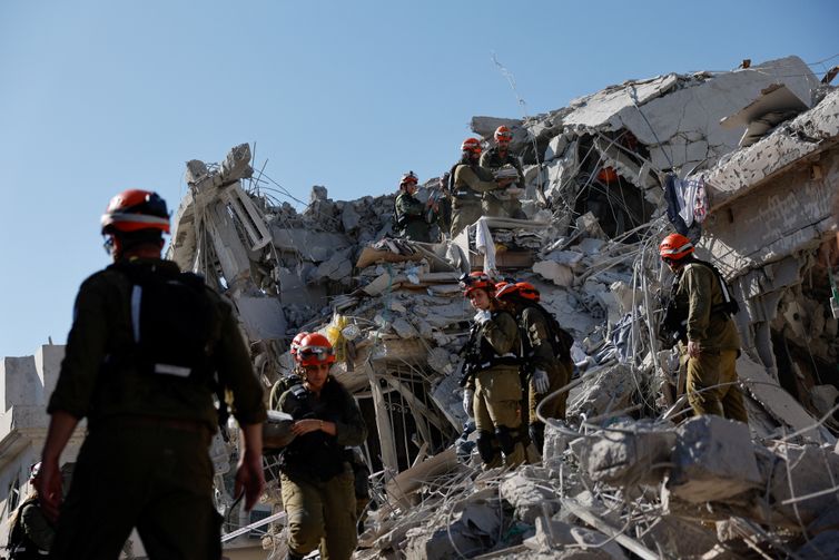 Israel- 14/06/2025 Equipe de resgate trabalha no local do impacto após um ataque de mísseis do Irã contra Israel, em Rishon LeZion, Israel, em 14 de junho de 2025. REUTERS/Ammar Awad/ Proibida reprodução.
