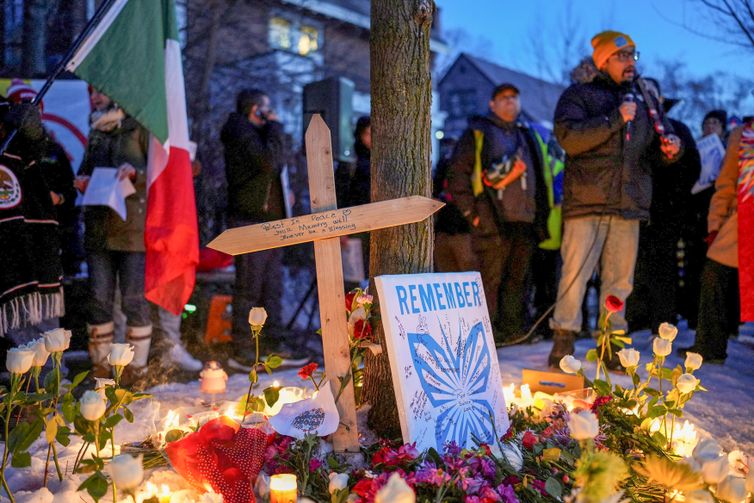 A message is written on a wooden cross placed next to flowers and candles at a memorial site during a vigil for a 37-year-old woman who was shot in her car by a U.S. immigration agent, according to local and federal officials, in Minneapolis, Minnesota, U.S., January 7, 2026. REUTERS/Tim Evans